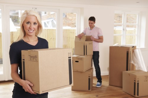 People preparing for a removals booking with packed boxes and moving equipment
